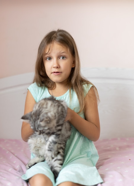 部屋に小さな子猫を持つ少女