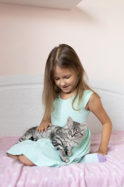 Girl with little kitten in the room