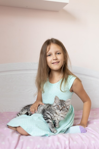 Girl with little kitten in the room