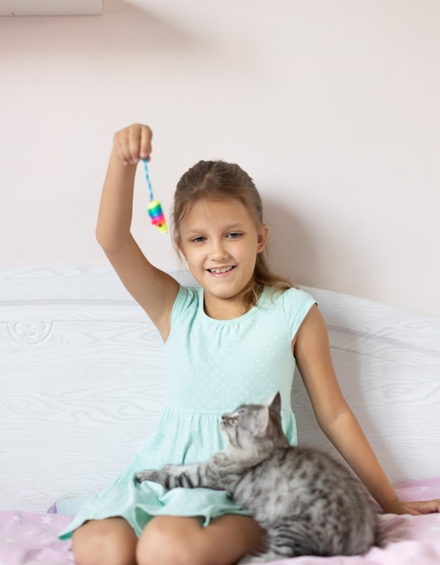 Girl with little kitten in the room