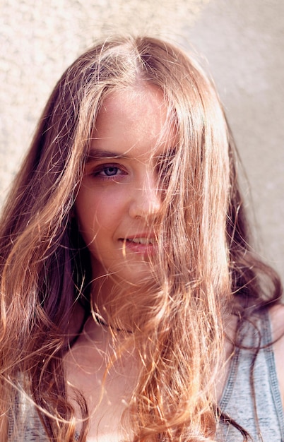 Девушка с длинными волосами, развивающимися на ветру и освещенными солнечными лучами