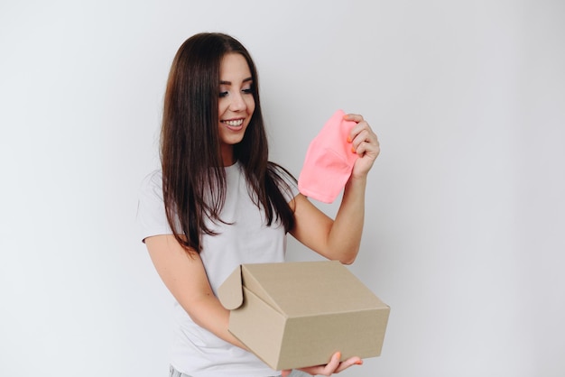 girl with long hair holds bright protective mask in her hands with an open cardboard box