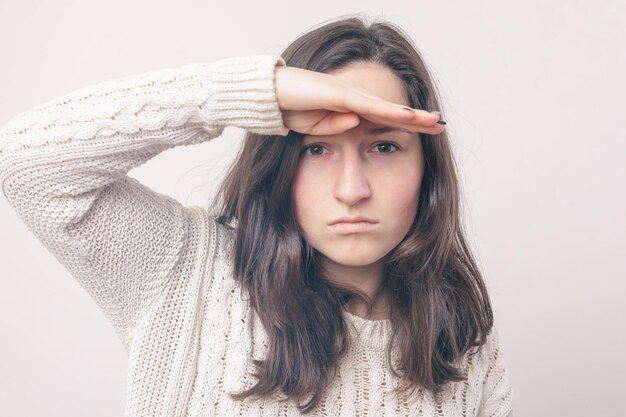 Girl with long hair is looking for something looking into the distance she put a hand to her forehead