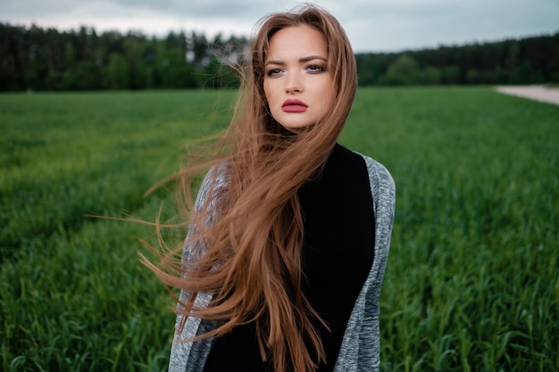 Girl with long hair standing in field in the wind The concept of freedom and passion