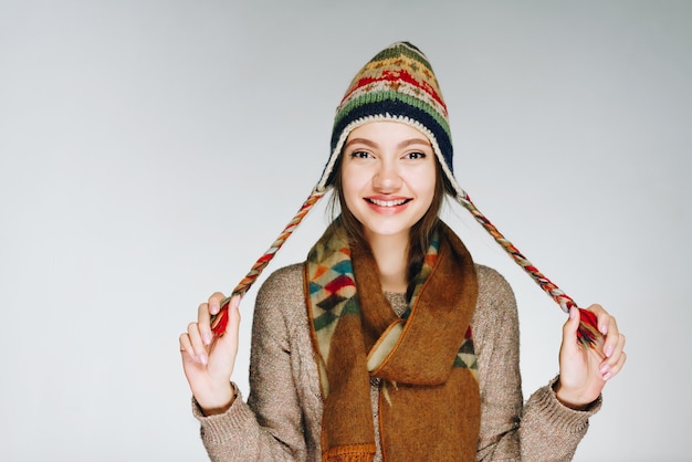 Girl with a lovely smile in a hat playfully posing