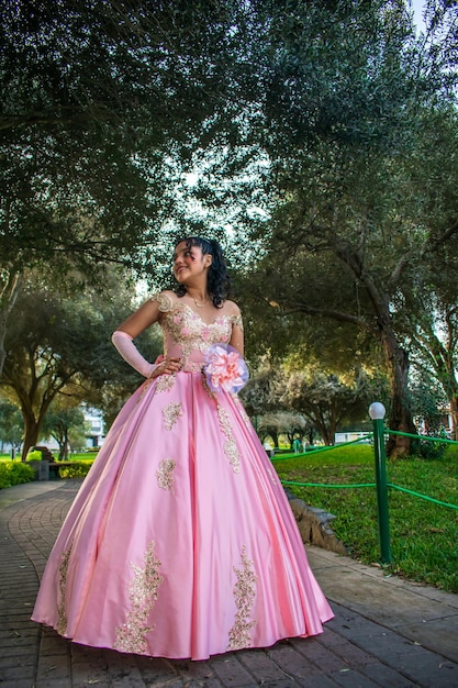 Girl with makeup and hairstyle in a princess dress in the middle of a park and green trees