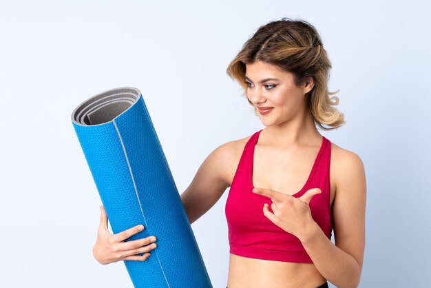 girl with mat isolated pointing to the side to present a product