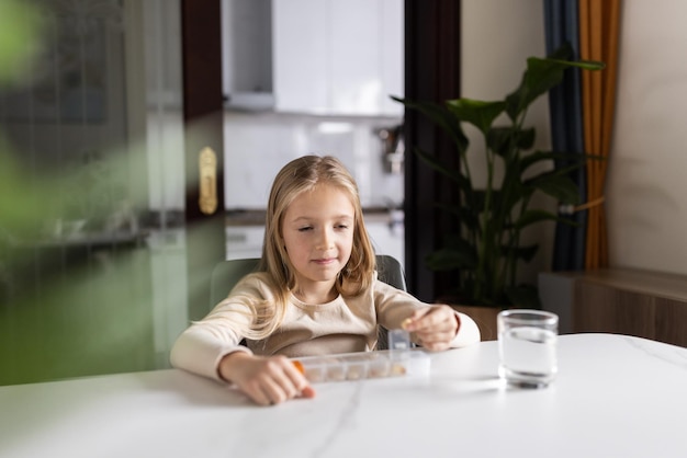 Фото Девушка с лекарством сидит за столом дома