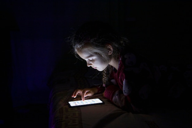 A girl with a mobile phone on the bed