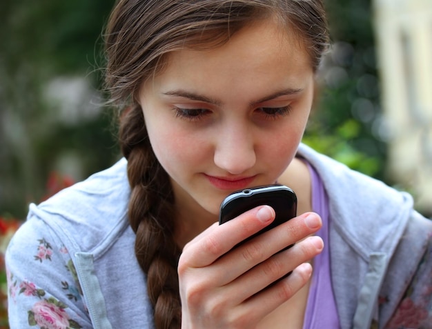 Девушка с мобильным телефоном читает сообщение