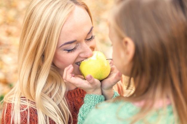 Girl with mother eating apple