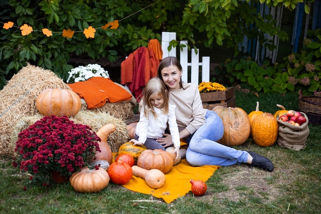 girl with mother outdoors with pumpkins