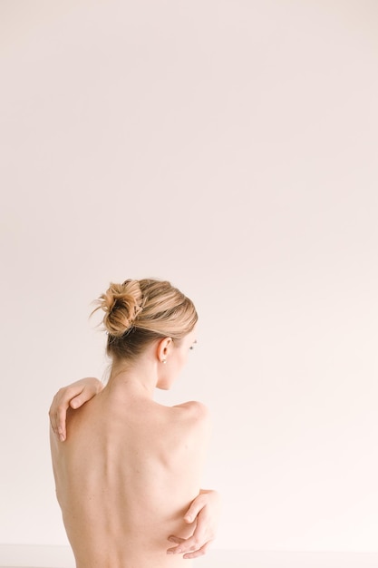 Girl with naked back hair tied in a pigtail white background