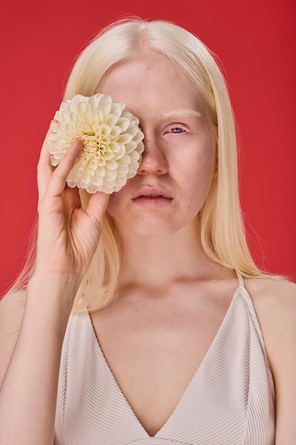 Ragazza con la bellezza naturale che posa con il fiore