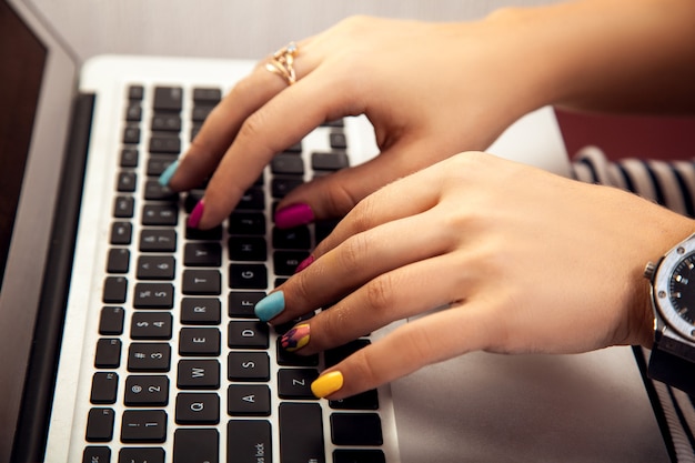 Girl with a nice manicure working at a laptop Worker