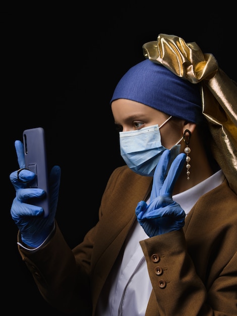 Photo girl with a pearl earring in a medical mask and glowes