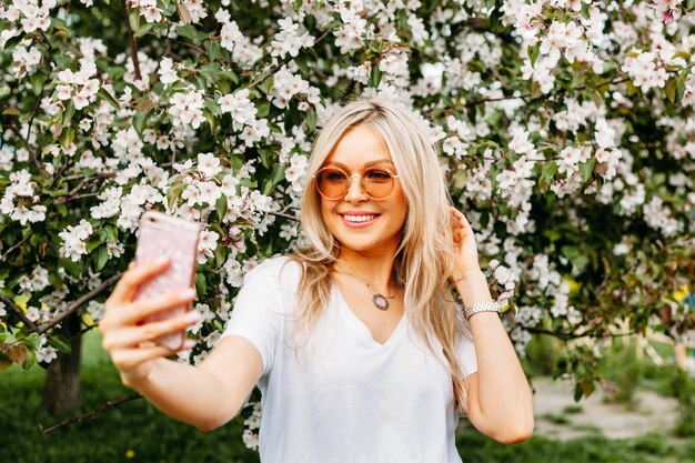 Photo a girl with a phone in her hand takes pictures of herself, selfies