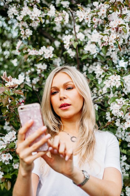 Photo a girl with a phone in her hand takes pictures of herself, selfies