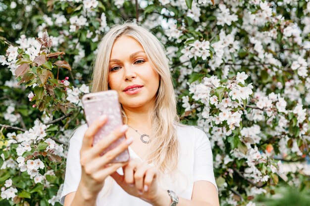 Photo a girl with a phone in her hand takes pictures of herself, selfies