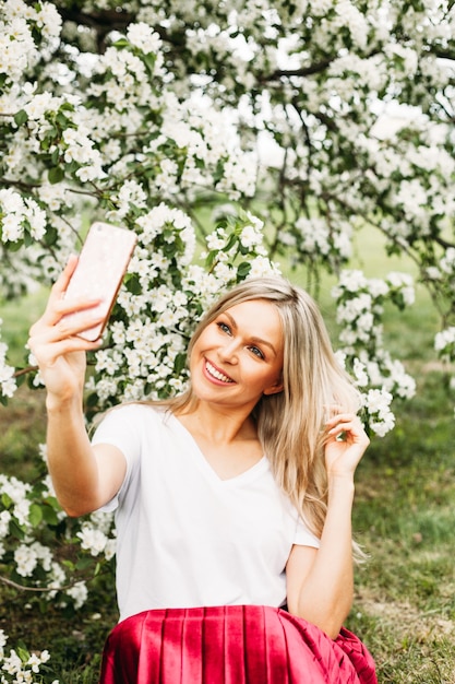 Photo a girl with a phone in her hand takes pictures of herself, selfies