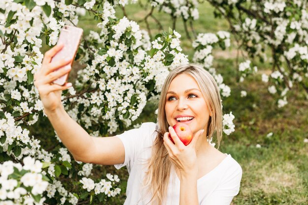 A girl with a phone in her hand takes pictures of herself, selfies