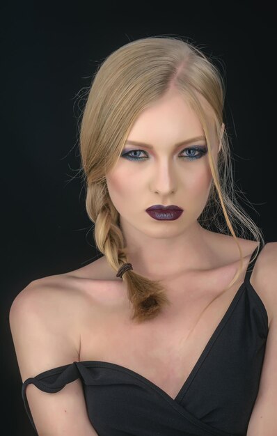 Girl with pigtail blond hair Makeup look and skincare of sensual girl Sexy woman with blonde hair isolated on black Hairdresser and beauty salon Fashion model with makeup and stylish hairdo