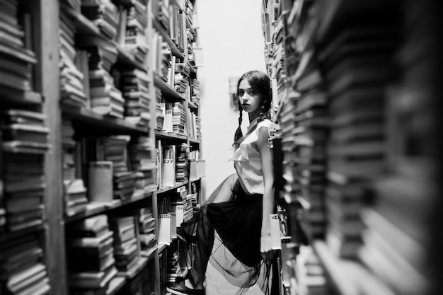 Girl with pigtails in white blouse at old library