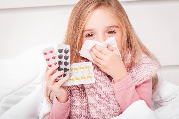 彼女の手に錠剤を持つ少女