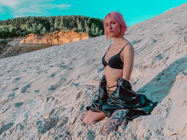 Girl with pink hair in a bathing suit against the sky