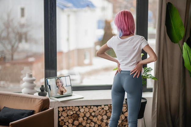 A girl with pink hair having a video call