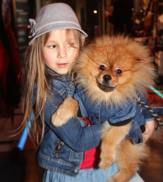 Photo girl with pomeranian looking away