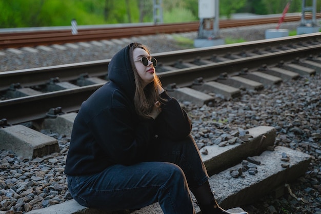 Girl with problems sits on the railroad