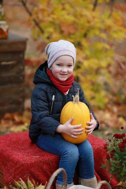 girl with pumpkin in autumn park