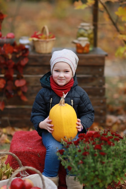 girl with pumpkin in autumn park