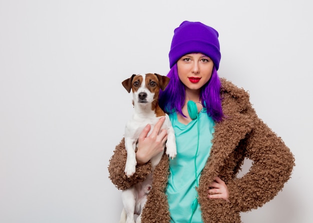 girl with purple hair in jacket holding dog