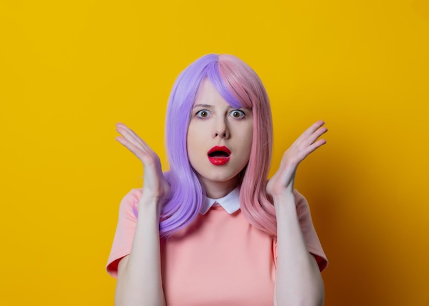 Girl with purple hair and pink dress on yellow background