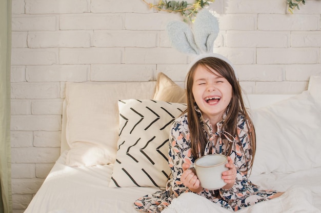 Girl with rabbit ears drinking tea