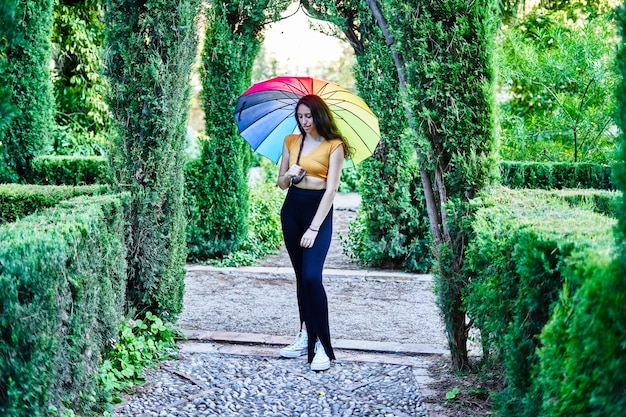 Girl with rainbow umbrella in the park LGBT concept