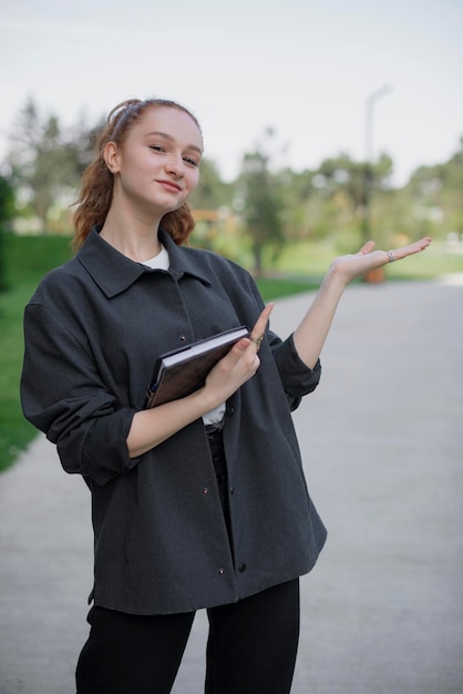 Girl with red hair standing in park wearing casual clothes