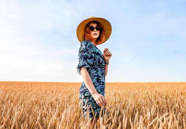 Girl with red hair in a wheat field