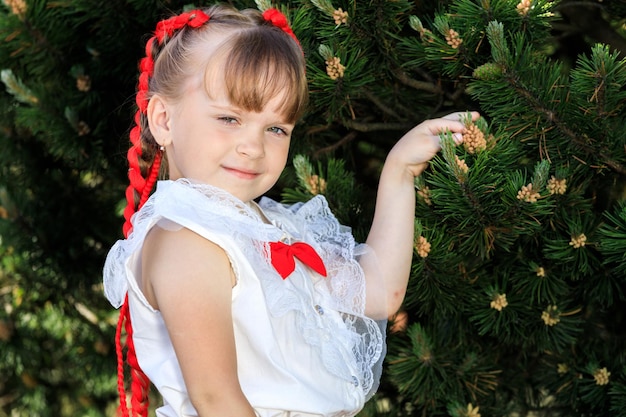 Girl with red pigtails in the park in summer