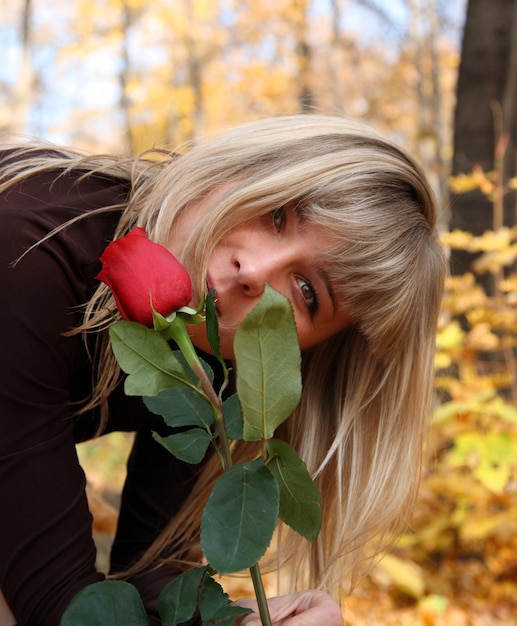 秋の公園でバラを持つ少女