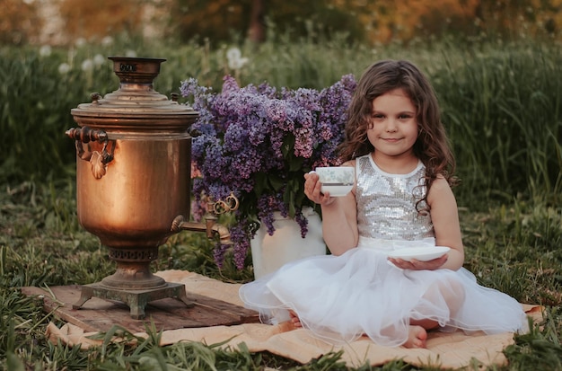 a girl with a samovar and lilac lilac flowers samovar a girl in a dress tea