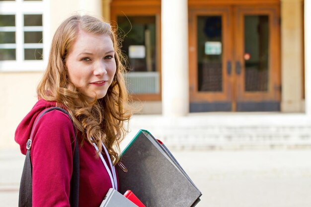 Foto ragazza con le cose della scuola nelle sue mani