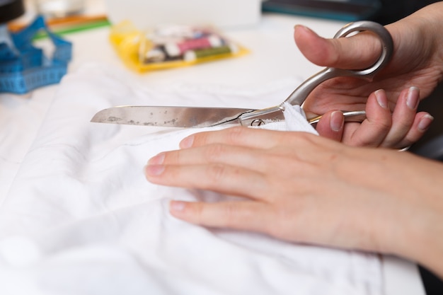 Girl with scissors cuts cloth