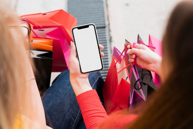 写真 携帯電話を保持している買い物袋を持つ少女