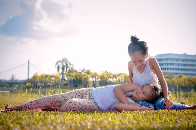 Girl with sister lying down on field