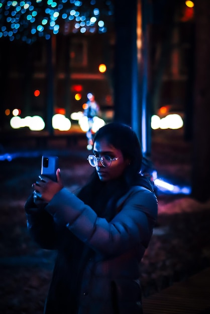 Photo girl with smartphone shot photo in the evening