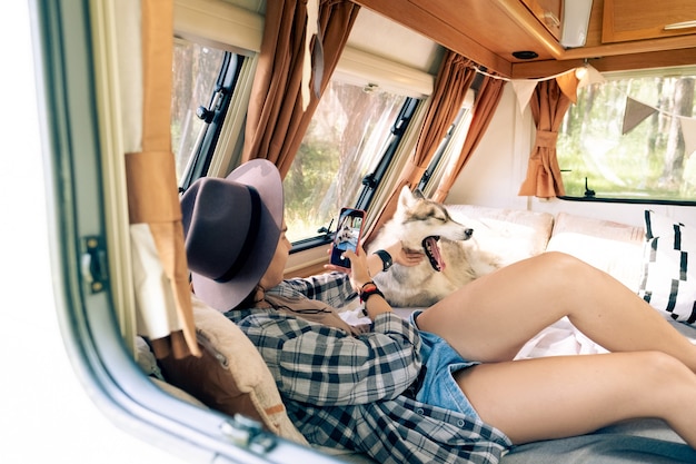 Girl with smartphone taking photo of yawning pet dog