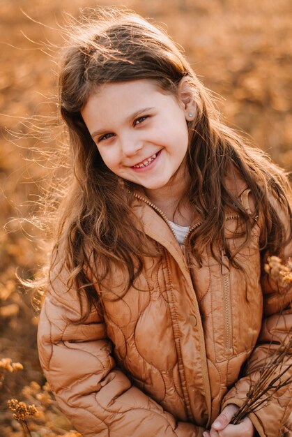 A girl with a smile A darkhaired girl The setting sun Evening light Dry grass Spring day